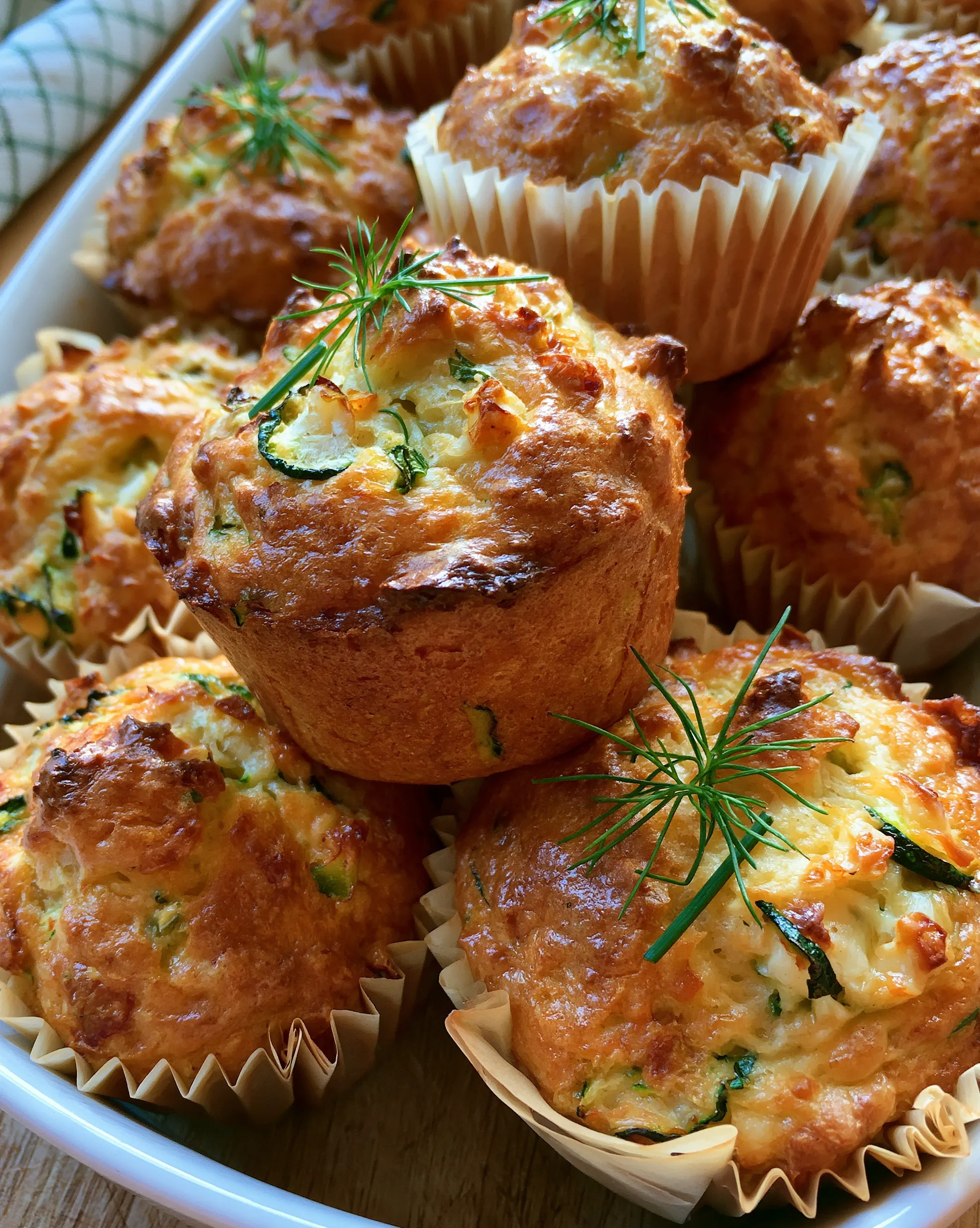 Easy zucchini muffins recipe — savory golden cheese-topped muffins with zucchini pieces and fresh dill